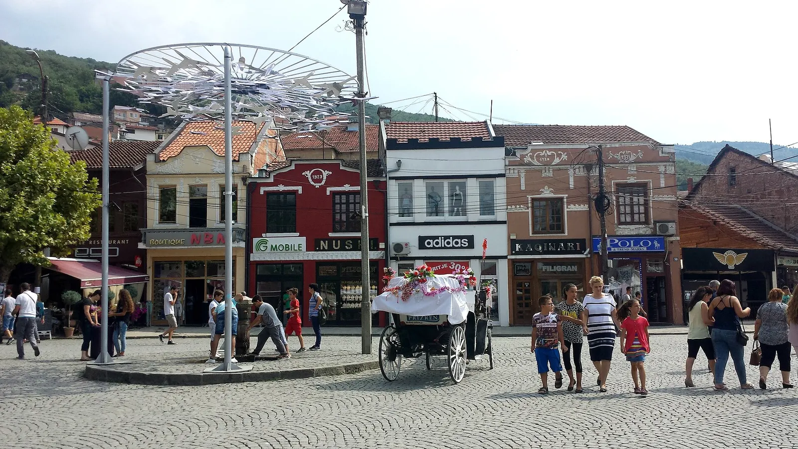 Shadërvan square in Prizren with shops and people walking